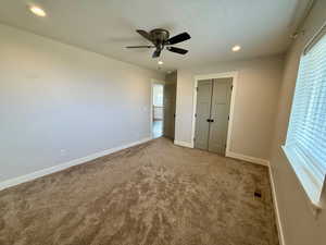 Unfurnished bedroom with recessed lighting, a closet, carpet, and a ceiling fan
