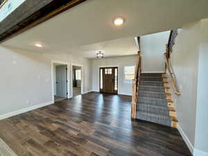 Foyer entrance featuring stairs and dark wood-type flooring