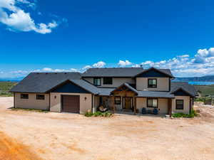 View of front facade with a shingled roof, a garage, dirt driveway, a mountain view, and a porch