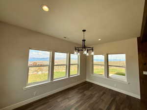 Unfurnished dining area featuring recessed lighting, a chandelier, and dark wood-style flooring