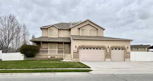 View of front of house featuring driveway, covered porch, stucco siding, a garage, and a shingled roof