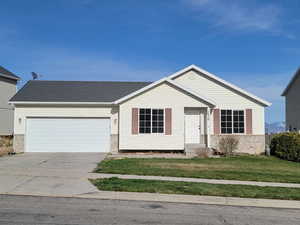 Ranch-style home with a garage, a front yard, concrete driveway, and brick siding