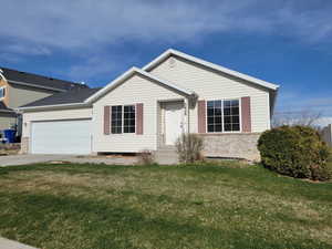 Ranch-style house with concrete driveway, a front yard, brick siding, and an attached garage