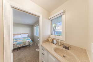 Bathroom with vanity, dark carpet, and connected bathroom