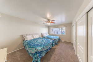 Bedroom featuring two closets, carpet, and ceiling fan
