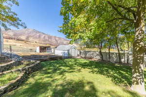 Fenced backyard featuring a storage unit and a mountain view