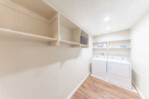 Laundry area with light wood-style floors and independent washer and dryer
