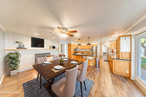 Dining room featuring ornamental molding, light wood-style flooring, and a ceiling fan