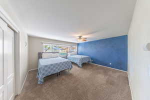 Carpeted bedroom with a closet and ceiling fan
