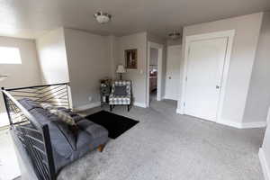 Living area with carpet flooring and baseboards