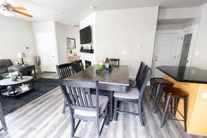 Dining space featuring light wood-style flooring, a ceiling fan, and baseboards