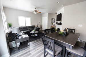 Dining room with light wood-style flooring, a ceiling fan, and visible vents