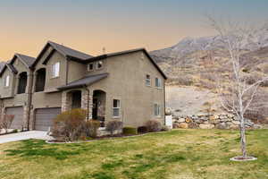 View of front of property with a front yard, a garage, and concrete driveway