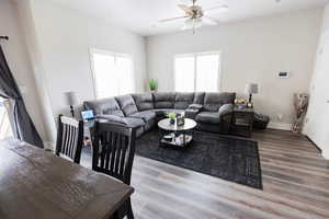 Living room featuring wood finished floors, baseboards, and a ceiling fan