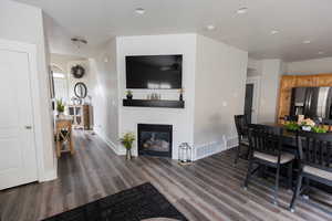 Interior space featuring wood finished floors, a fireplace, baseboards, and visible vents