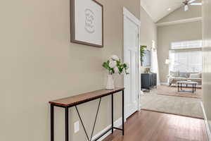 Corridor featuring baseboards, high vaulted ceiling, and wood finished floors