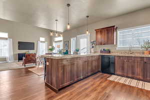 Kitchen with a wealth of natural light, a sink, a peninsula, open floor plan, and black dishwasher