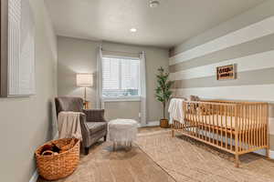 Carpeted bedroom with baseboards and a textured ceiling