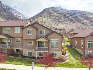 Exterior space featuring stucco siding, a mountain view, and a front yard
