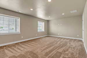 Unfurnished room with light carpet, baseboards, and recessed lighting