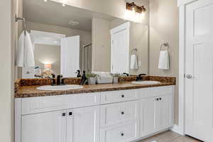 Full bath featuring tile patterned floors, a sink, and double vanity