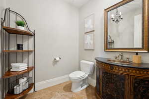 Half bath featuring Bombay style vanity, and a chandelier