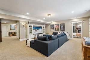Living room featuring light colored carpet, recessed lighting and a separate entry.