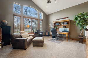 Home office with baseboards, carpet floors, and high vaulted ceiling