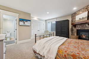 Bedroom with carpet floors, a fireplace, a huge closet and recessed lighting