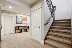 Staircase featuring carpet, baseboards, and recessed lighting