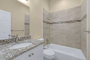 Bathroom with vanity,  shower combination, and toilet