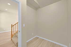 Spare room with light wood finished floors, baseboards, stairs, and recessed lighting