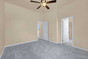Unfurnished bedroom with ceiling fan, carpet flooring, baseboards, and a spacious closet