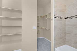 Full bath featuring bathing tub / shower combination, baseboards, and a walk in closet