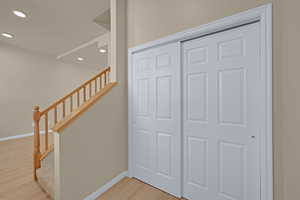 Stairs with baseboards, recessed lighting, and wood finished floors