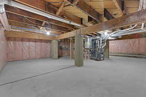 Unfinished below grade area featuring heating unit