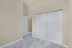 Unfurnished bedroom featuring a closet, baseboards, and carpet flooring