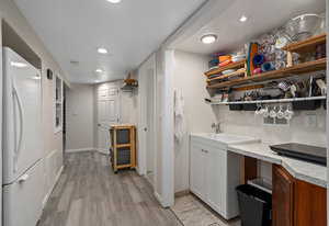 Kitchen featuring freestanding refrigerator, light wood-style flooring, open shelves, recessed lighting, and light countertops