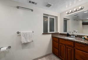 Bathroom featuring tile patterned floors, vanity, visible vents, and baseboards