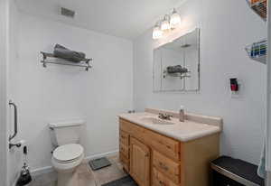 Bathroom featuring vanity, tile patterned flooring, visible vents, toilet, and baseboards