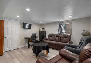 Living room with light wood-style flooring and recessed lighting