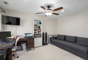 Carpeted home office with ceiling fan, visible vents, and recessed lighting