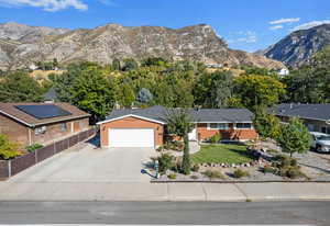 View of front of house with concrete driveway, fence, a mountain view, and a garage