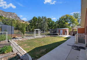 View of yard with a garden, fence, and an outbuilding