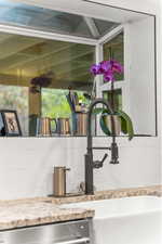 Room details featuring dishwasher, light stone countertops, and decorative backsplash