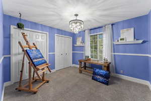 Misc room featuring baseboards, carpet flooring, and a chandelier