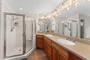 Full bath with a sink, a stall shower, and tile patterned flooring
