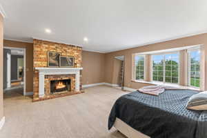 Bedroom featuring multiple windows, crown molding, and a brick fireplace