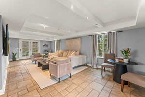 Living area featuring baseboards, beamed ceiling, stone tile floors, and recessed lighting