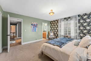 Bedroom with carpet flooring, wallpapered walls, connected bathroom, and baseboards